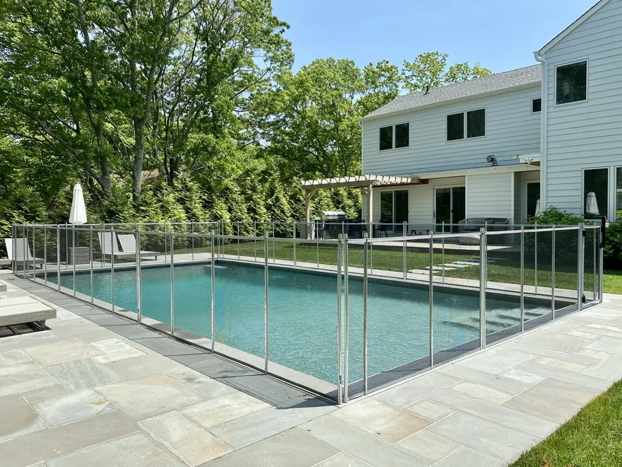 Guardian removable mesh pool fence installed by Sunrise around an in-ground pool and bluestone patio