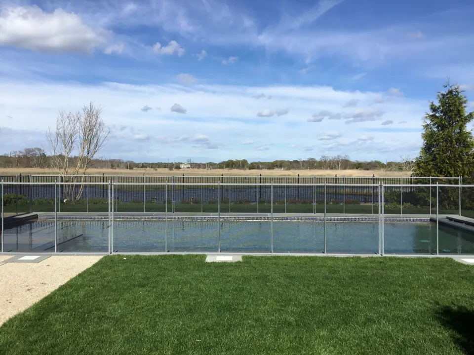 Guardian Vanishing removable pool fence viewed across the lawn at an East Islip waterfront residence