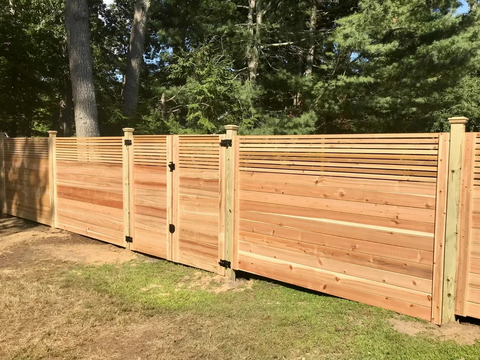 Corner view of a horizontal cedar fence with spaced upper boards in Westhampton, New York