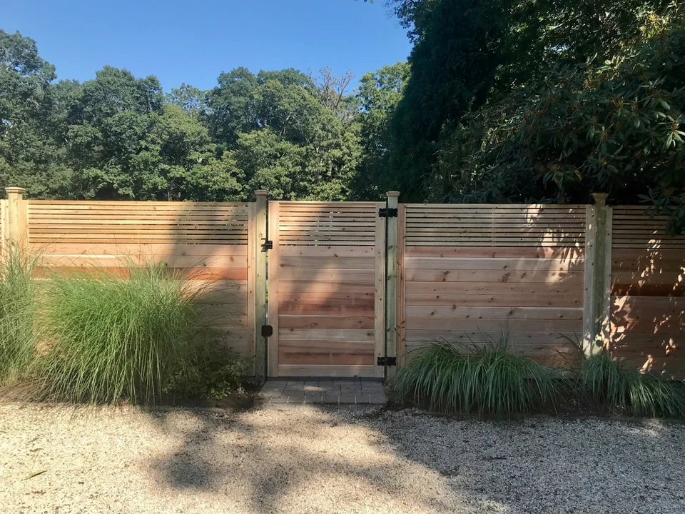 Custom horizontal cedar gate with black hardware and capped pressure-treated posts in Westhampton