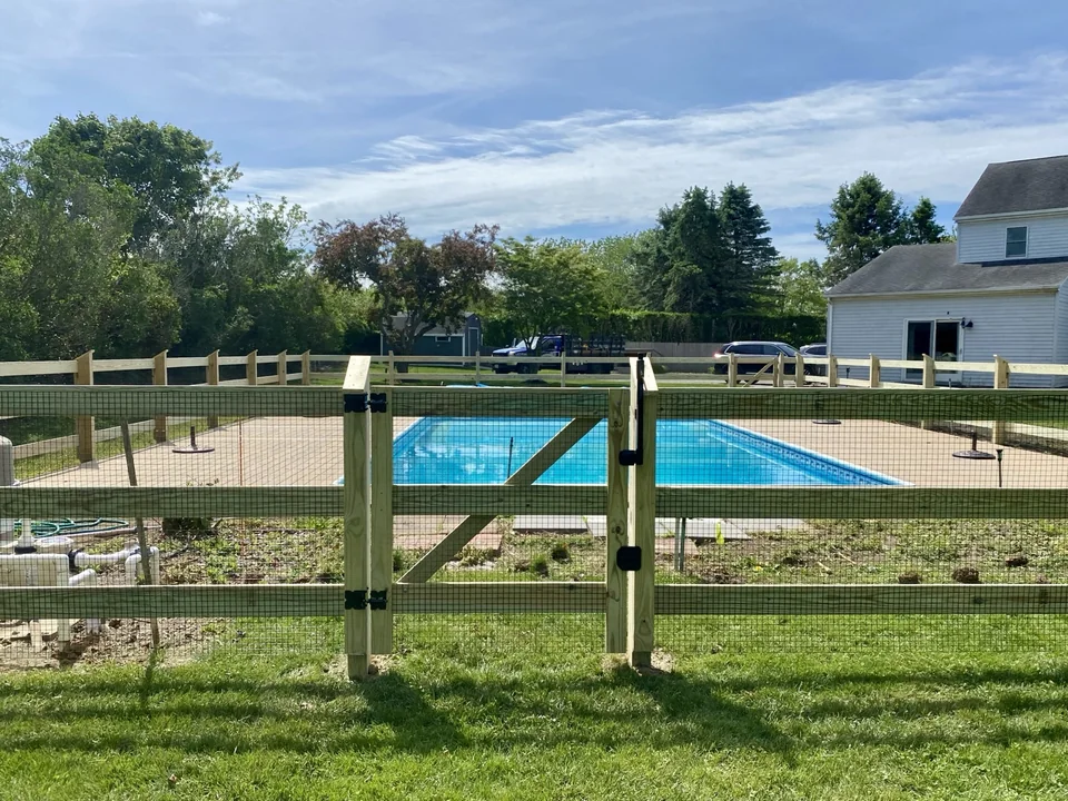 Centered custom gate in a pool-code post and rail wire fence