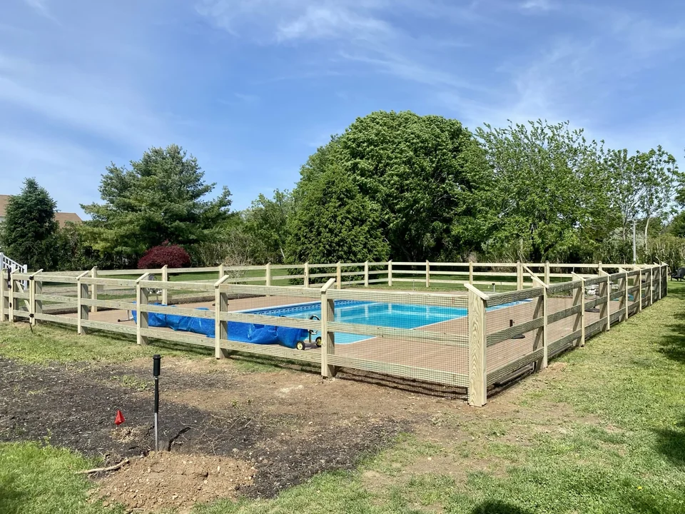 Full corner overview of Aquebogue post and rail wire pool fence
