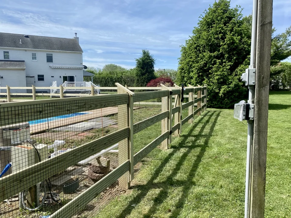 Long side-yard run of custom post and rail wire pool fencing