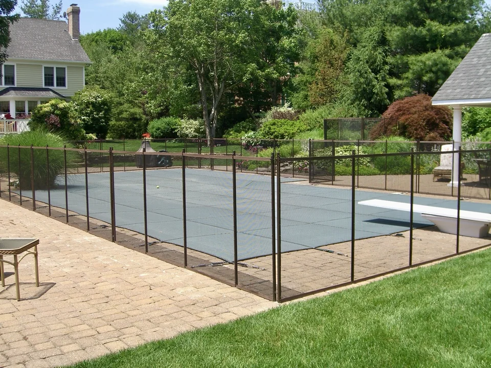 Guardian mesh pool safety fence in a landscaped Melville, New York backyard