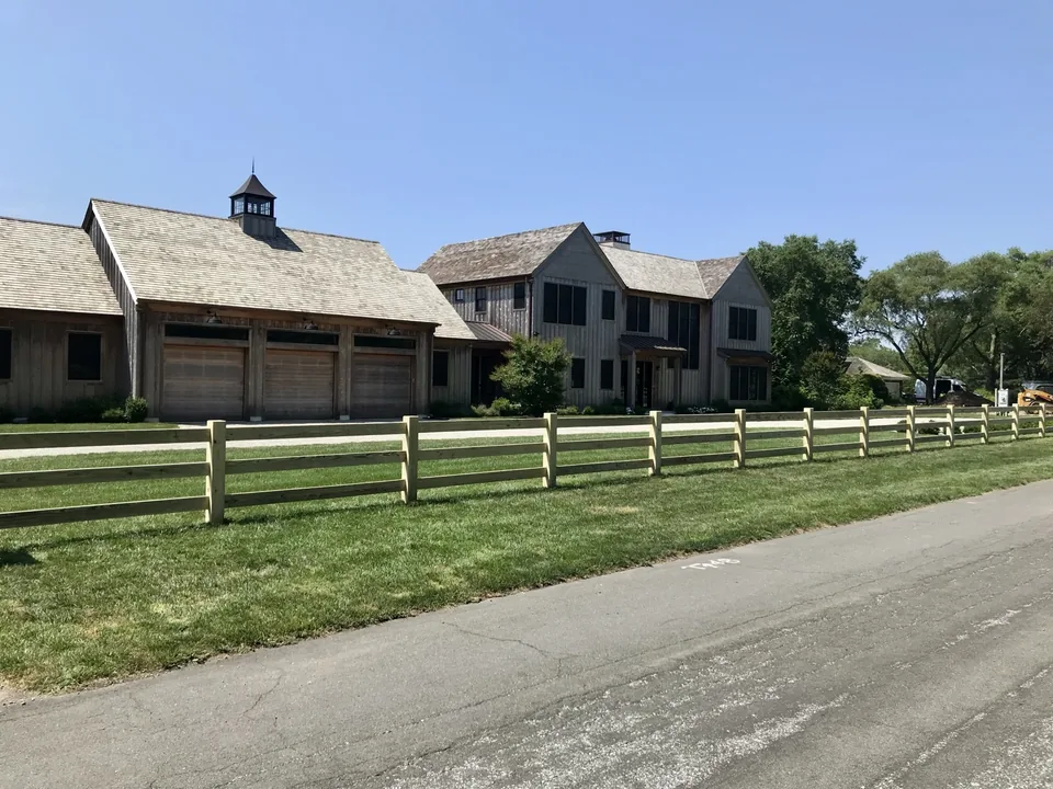 Custom post and rail fence spanning a Remsenburg property
