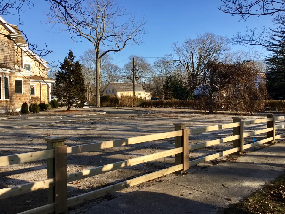 Corner perspective of custom board fencing with cedar post caps in Remsenburg, New York.