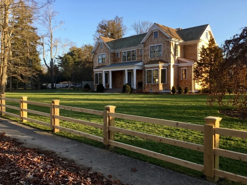 Custom three-rail board fence with digitally finished lawn at a Remsenburg home.