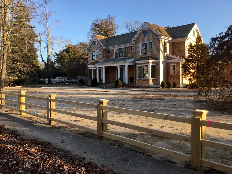 Original job-site view of custom three-rail board fencing in Remsenburg, New York.