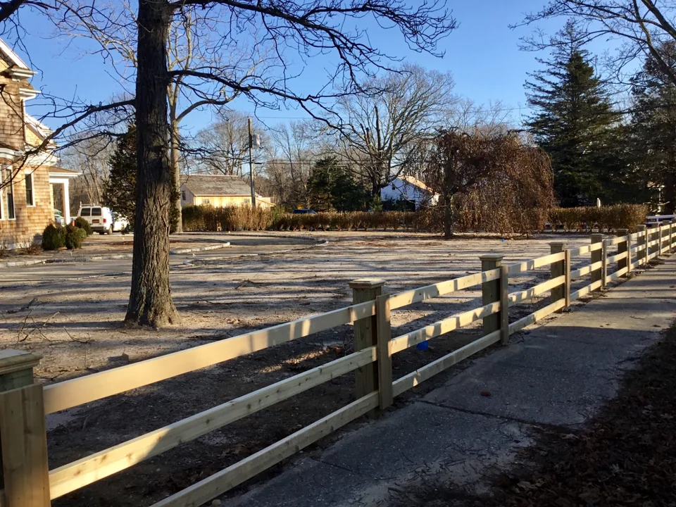Long run of custom three-rail board fencing along a Remsenburg property.