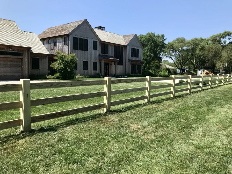 Pressure-treated post and rail fence along a Remsenburg property line