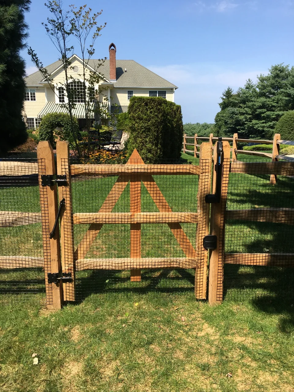 Split rail fence with wire and matching gate in Southold, New York.