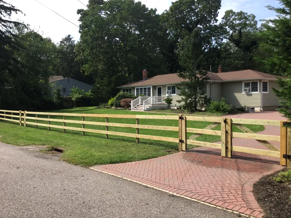 Frontage view of a three-rail board fence in Speonk, New York.