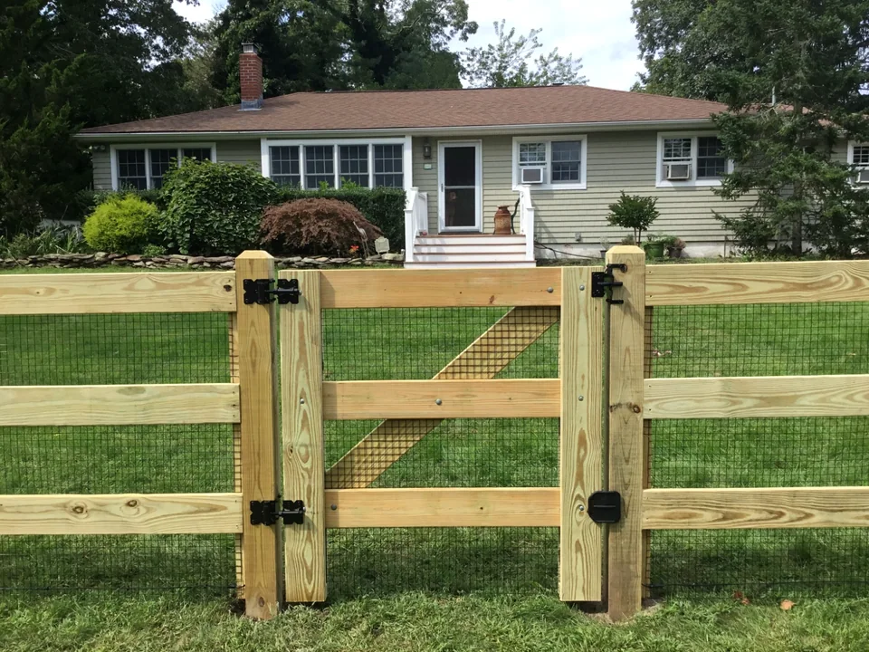 Three-rail board fence with matching gate in Speonk, New York.