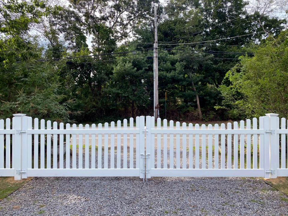 Centered view of a white PVC picket double driveway gate in Speonk, New York.