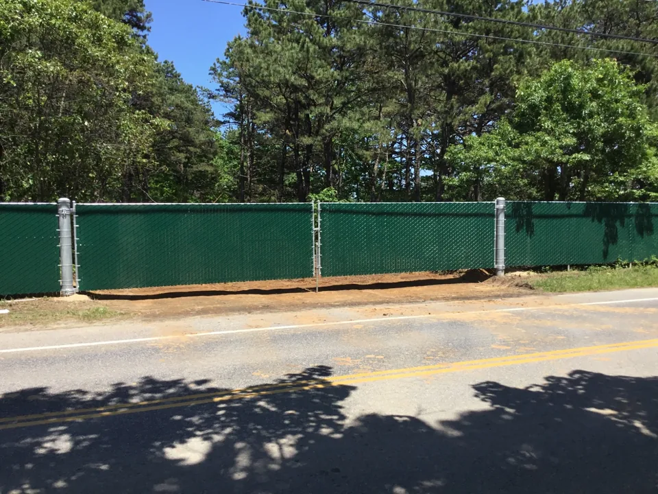 Large green privacy chain link gate spanning a thirty-six-foot opening