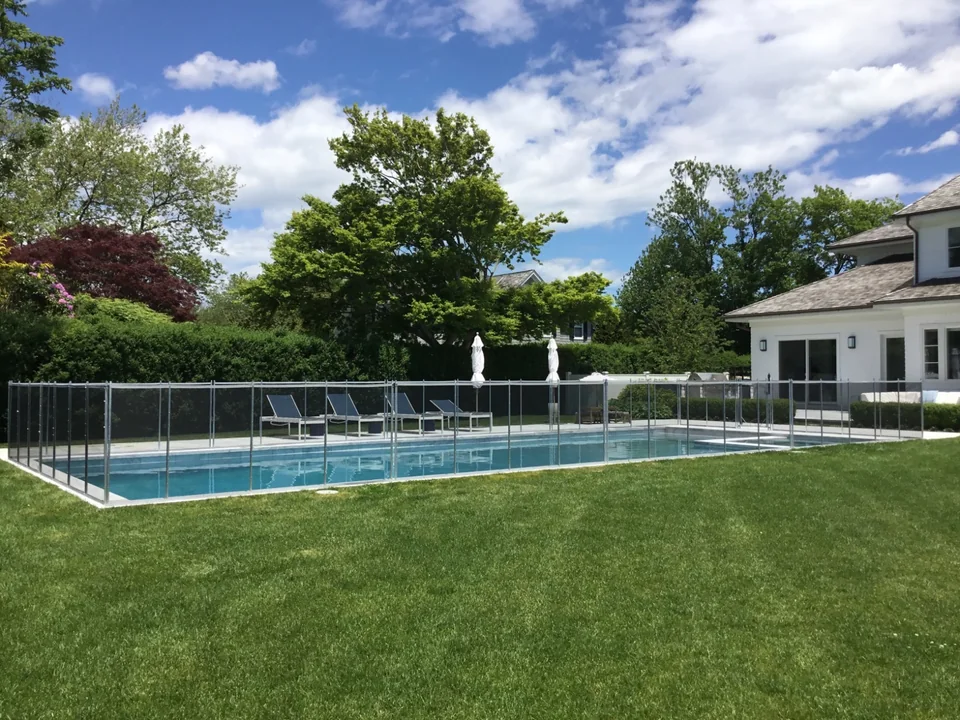 Transparent removable mesh pool fence in a landscaped Southampton backyard