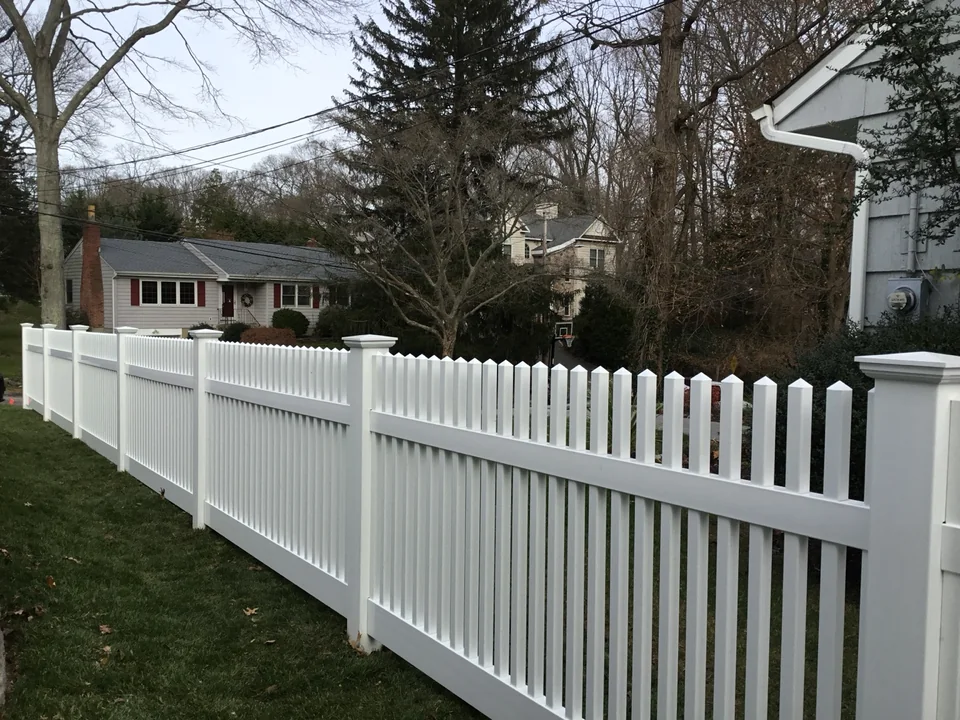 White PVC Victorian picket fence transitioning to taller privacy sections in Locust Valley, New York