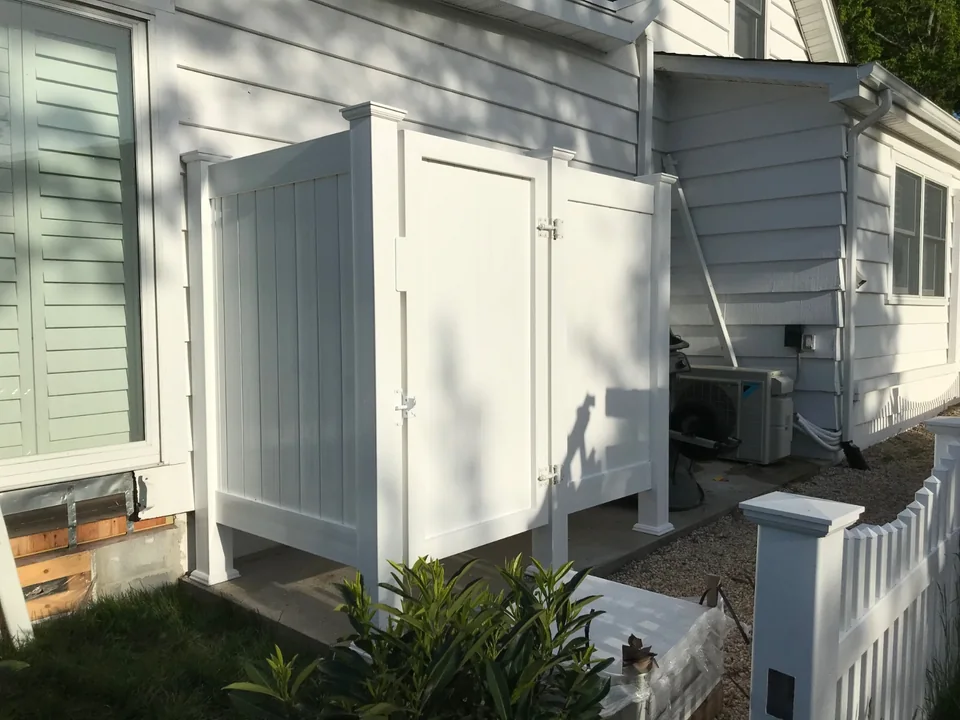 Side view of a white PVC outdoor shower enclosure at a Southold, New York home.