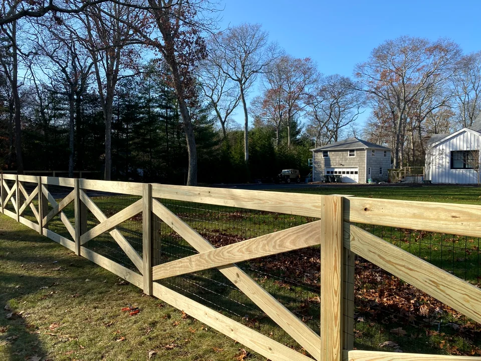 Close perspective of pressure-treated crossbuck fence and wire infill in Westhampton.