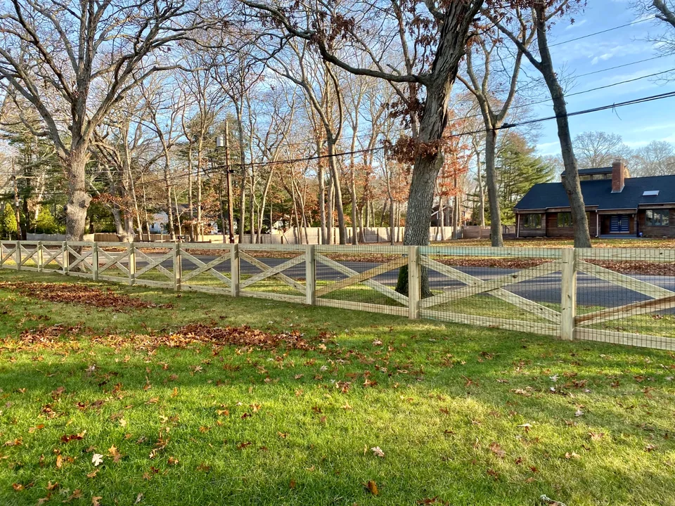 Landscape view of custom pressure-treated crossbuck fencing in Westhampton, NY.