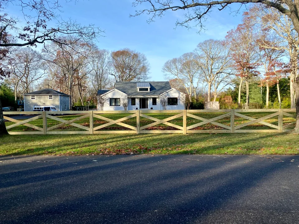 Street-side view of custom pressure-treated crossbuck fencing in Westhampton, New York.