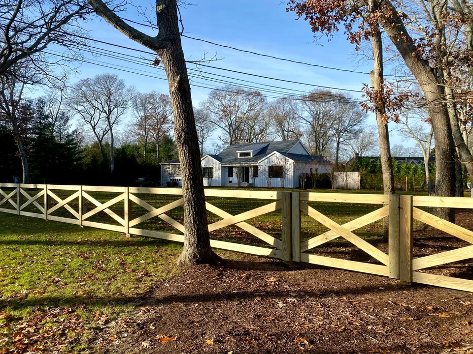 Long run of pressure-treated crossbuck post and rail fencing in Westhampton, New York.