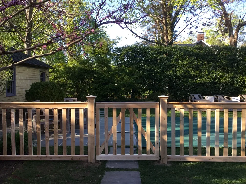 Front view of a custom-built white cedar gate and capped posts in Bellport Village